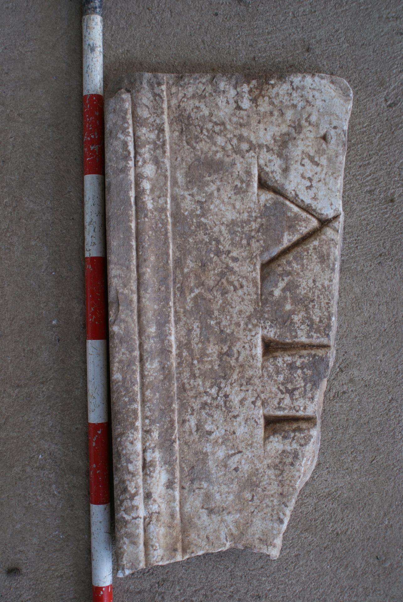 Placa de mármol reutilizada en la cubierta de una de las sepulturas del cementerio andalusí